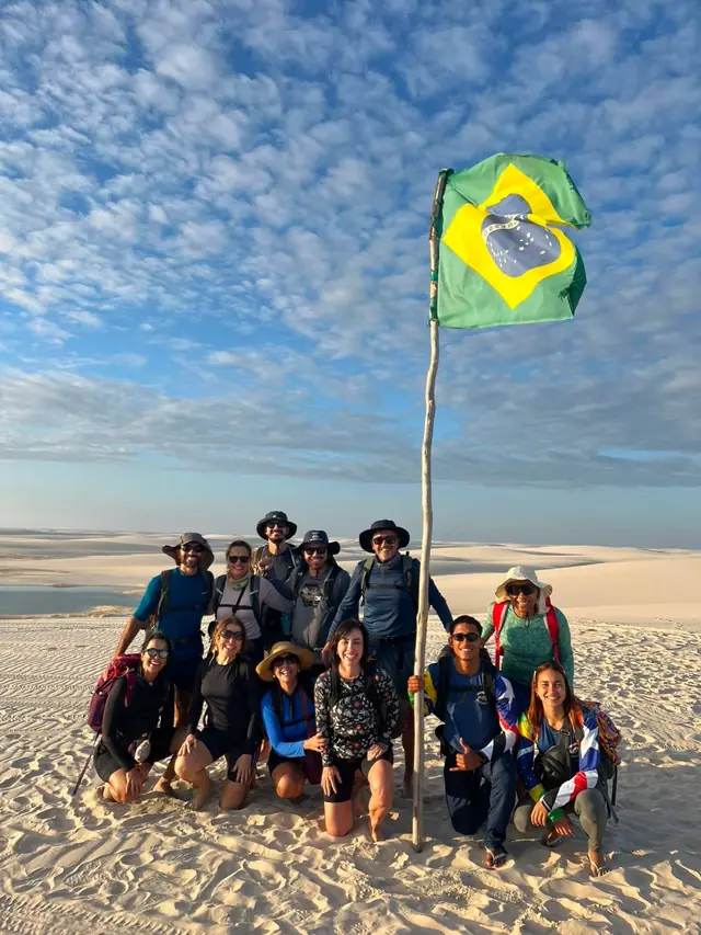 Grupo com a bandeira do Brasil no topo das dunas