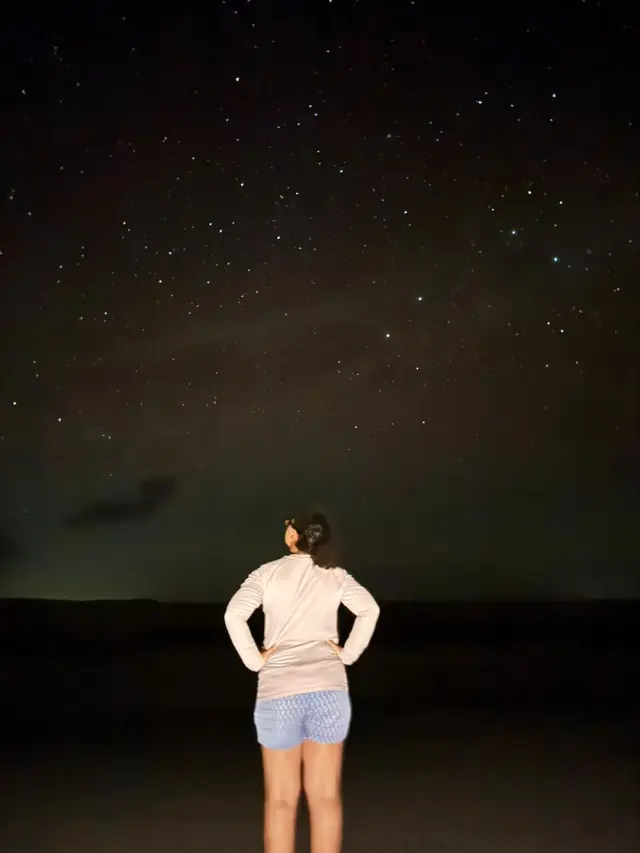 Viajante de costas contemplando o céu estrelado dos Lençóis