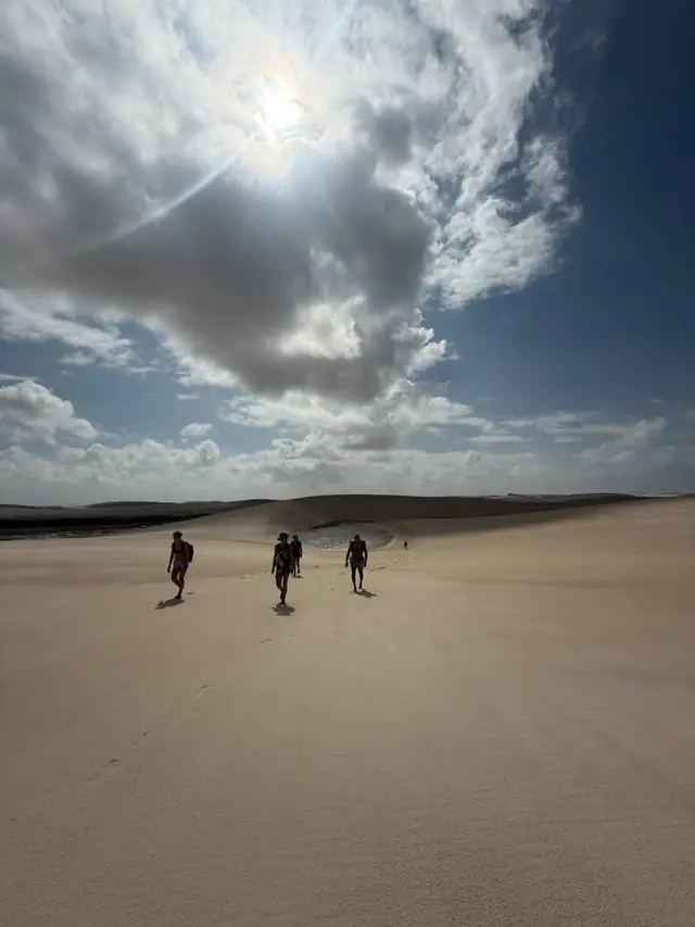 Grupo atravessando o campo de dunas com o sol a pino