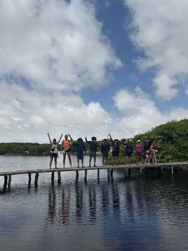 Grupo em ponte de madeira sobre lagoa