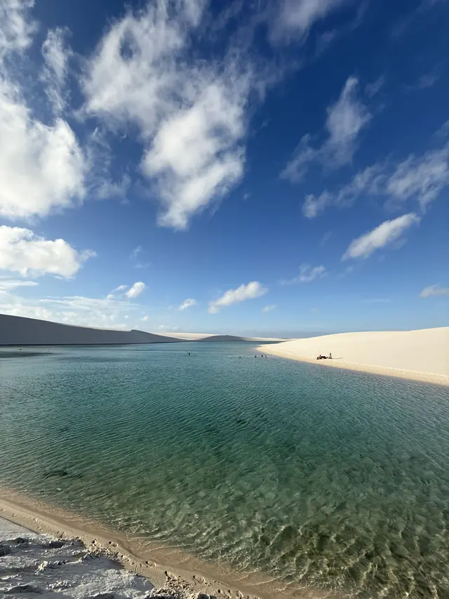 Lagoa de água esmeralda entre dunas brancas